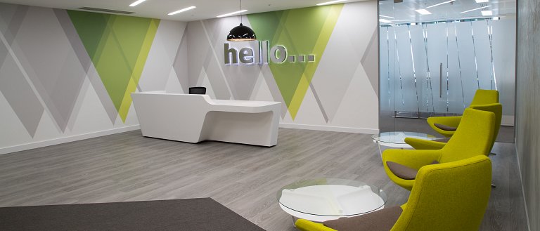 Main reception with halo illuminated built-up stainless steel wall-mounted letters and glass frosting