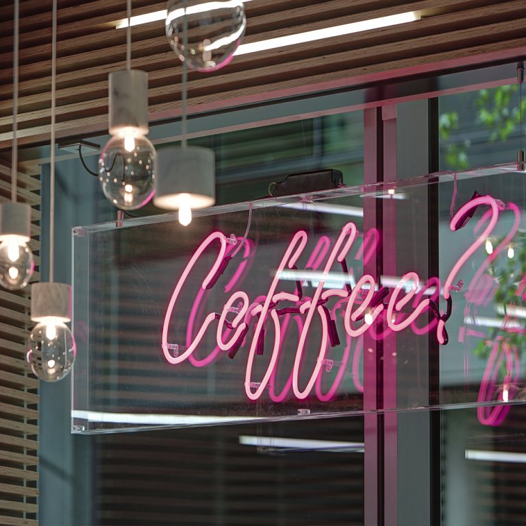 Pink neon 'coffee' sign mounted in a perspex box